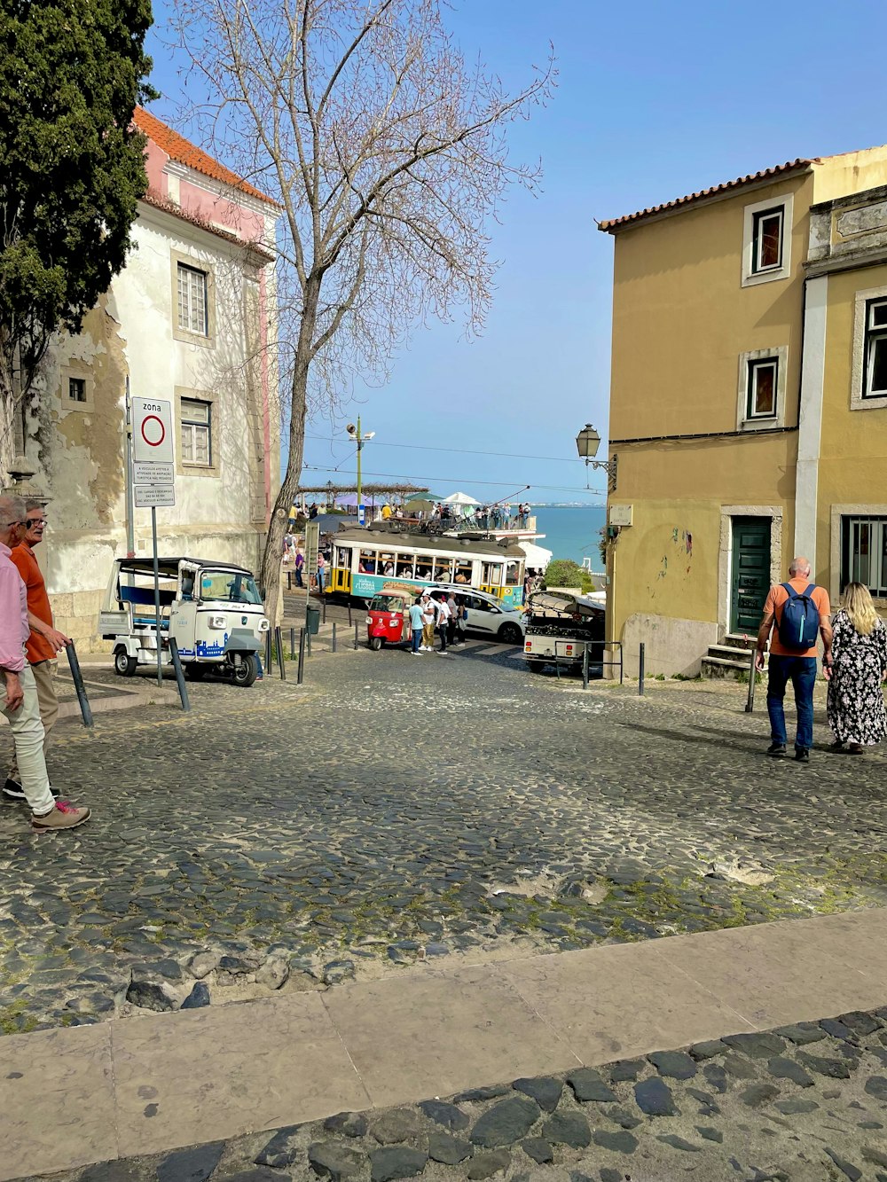 a group of people walking down a cobblestone street