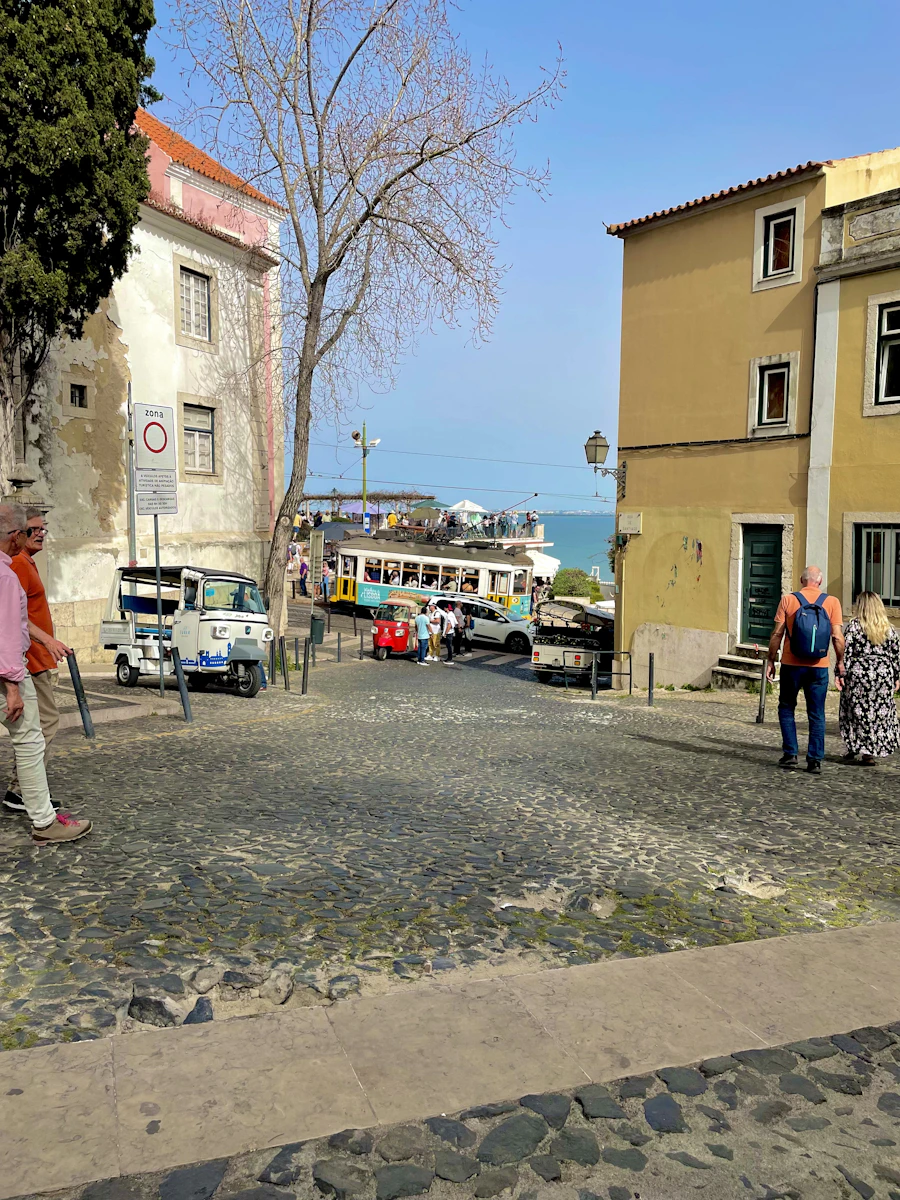 Homem caminhando por rua de paralelepípedos no bairro de Alfama, Lisboa, representando nacionalidade por tempo de residência
