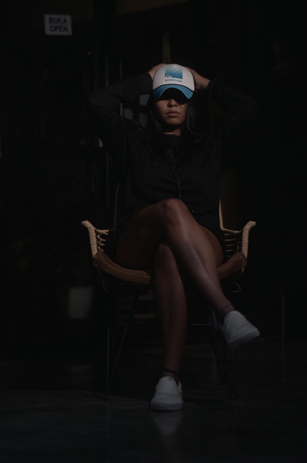 a woman sitting in a chair with a hat on her head