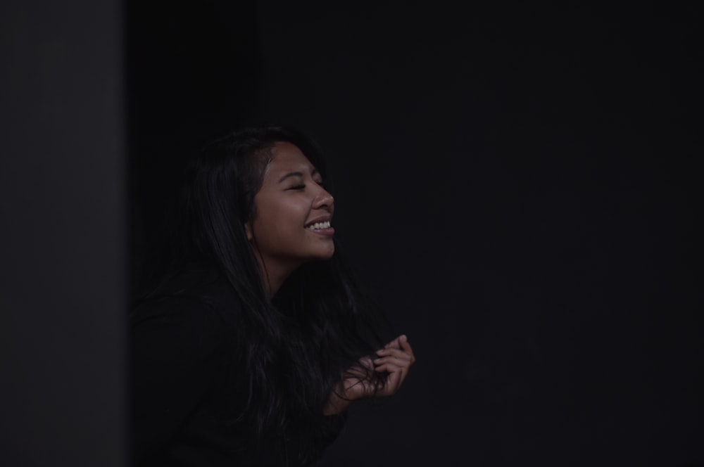 a woman standing in the dark laughing