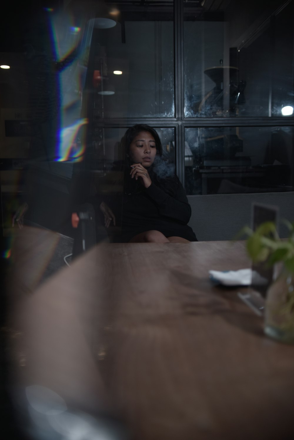 a woman sitting at a table in a dark room