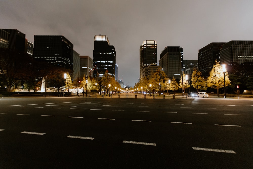 a city street at night with tall buildings