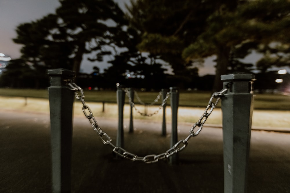 a chain link fence in a park at night