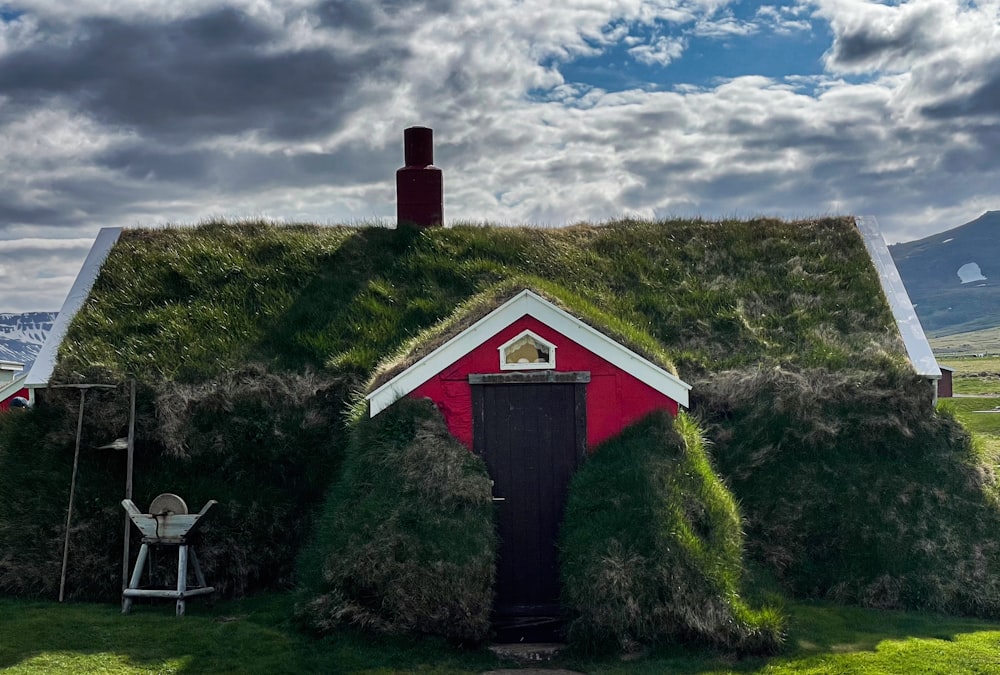 잔디 지붕이 있는 빨간색과 흰색의 집