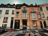 Exterior shot of a renovated townhouse blending modern and classic Belgian architecture.