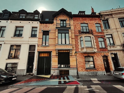 Exterior shot of a renovated townhouse blending modern and classic Belgian architecture.