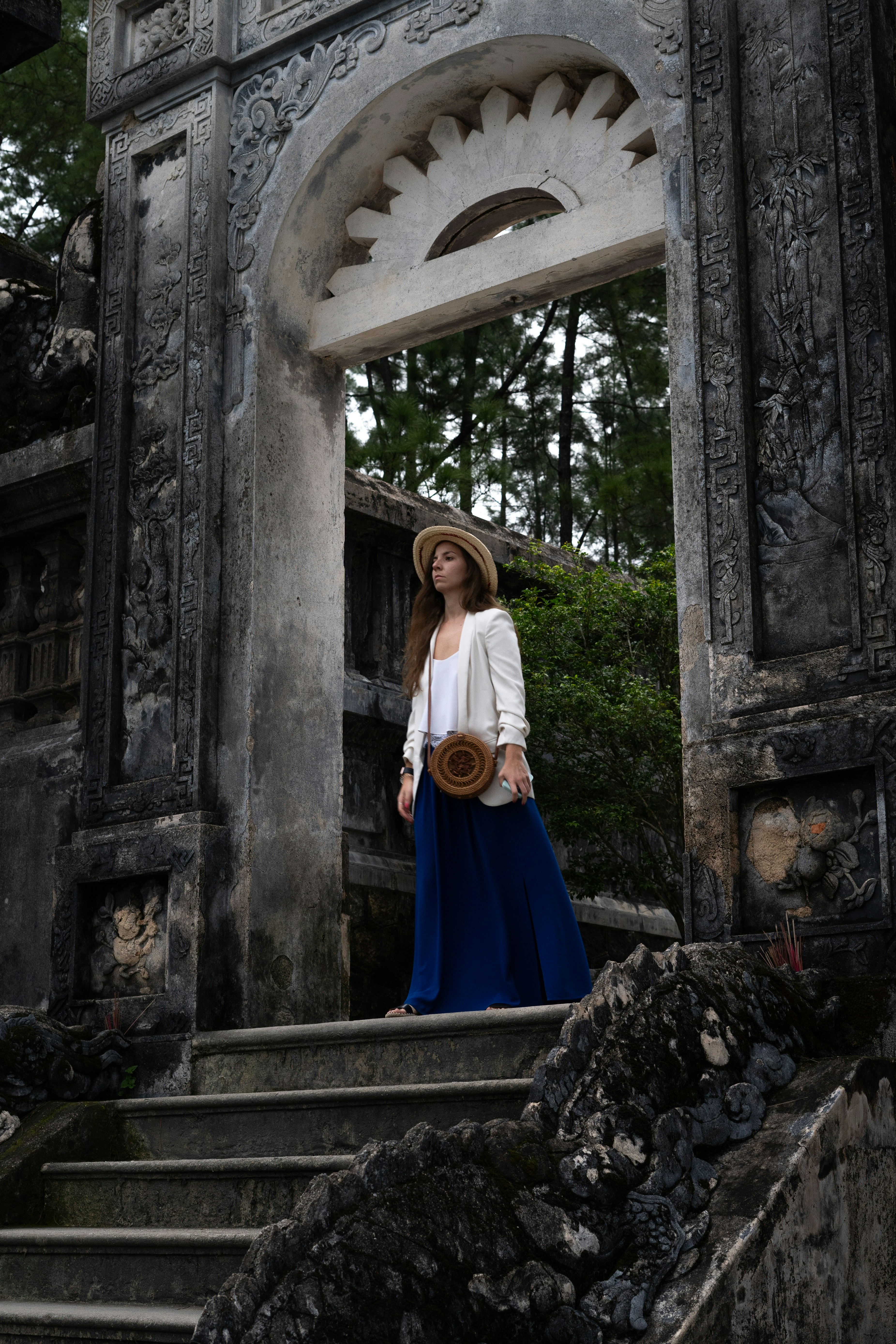 a woman in a hat is standing on some steps