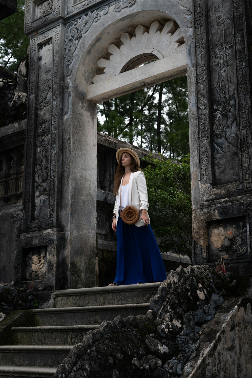 a woman in a hat is standing on some steps