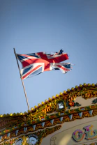 a british flag flying on top of a carnival ride