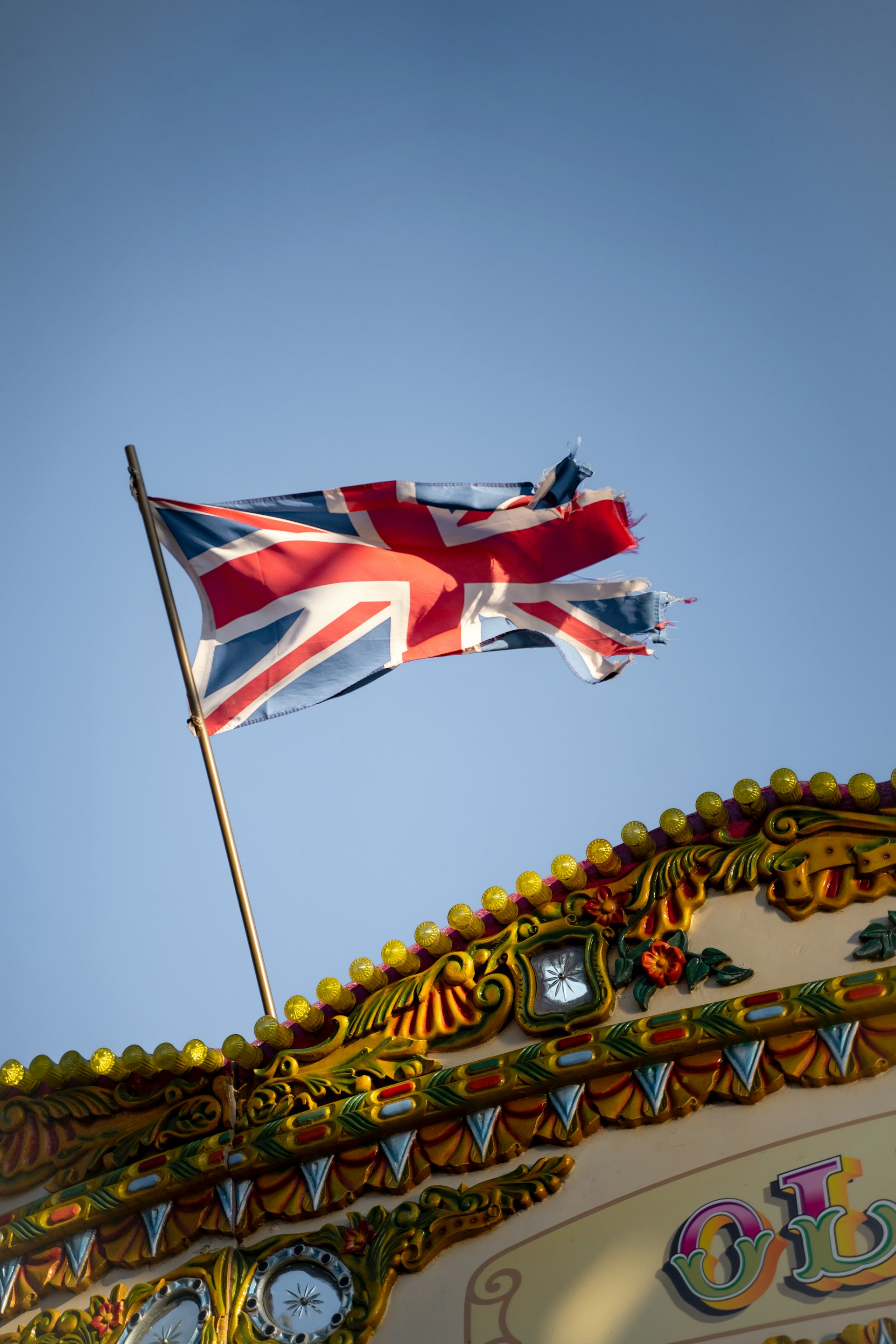 a british flag flying on top of a carnival ride