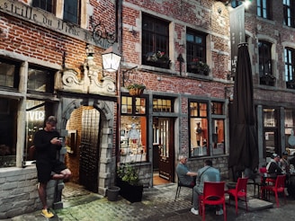 a man sitting at a table in front of a building
