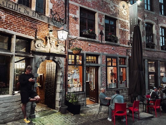 a man sitting at a table in front of a building
