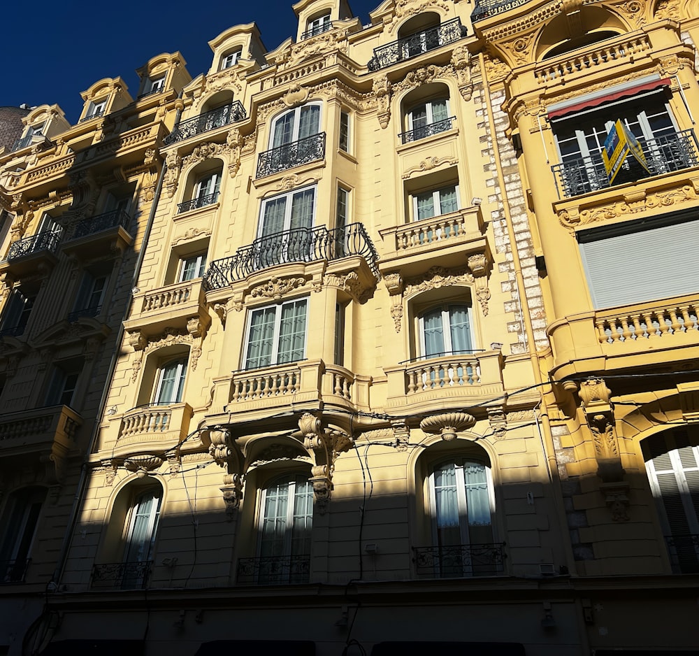 a tall yellow building with balconies and balconies