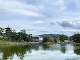 A serene video still of a calm lake reflecting surrounding Asian temples at dawn.