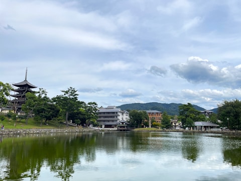 A serene video still of a calm lake reflecting surrounding Asian temples at dawn.