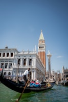 a gondola in a canal with a tall building in the background