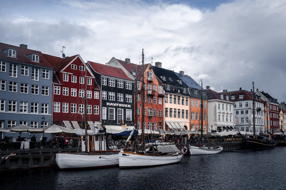 a row of boats sitting next to a row of buildings