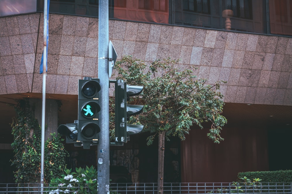 Un semáforo sentado al lado de un edificio alto