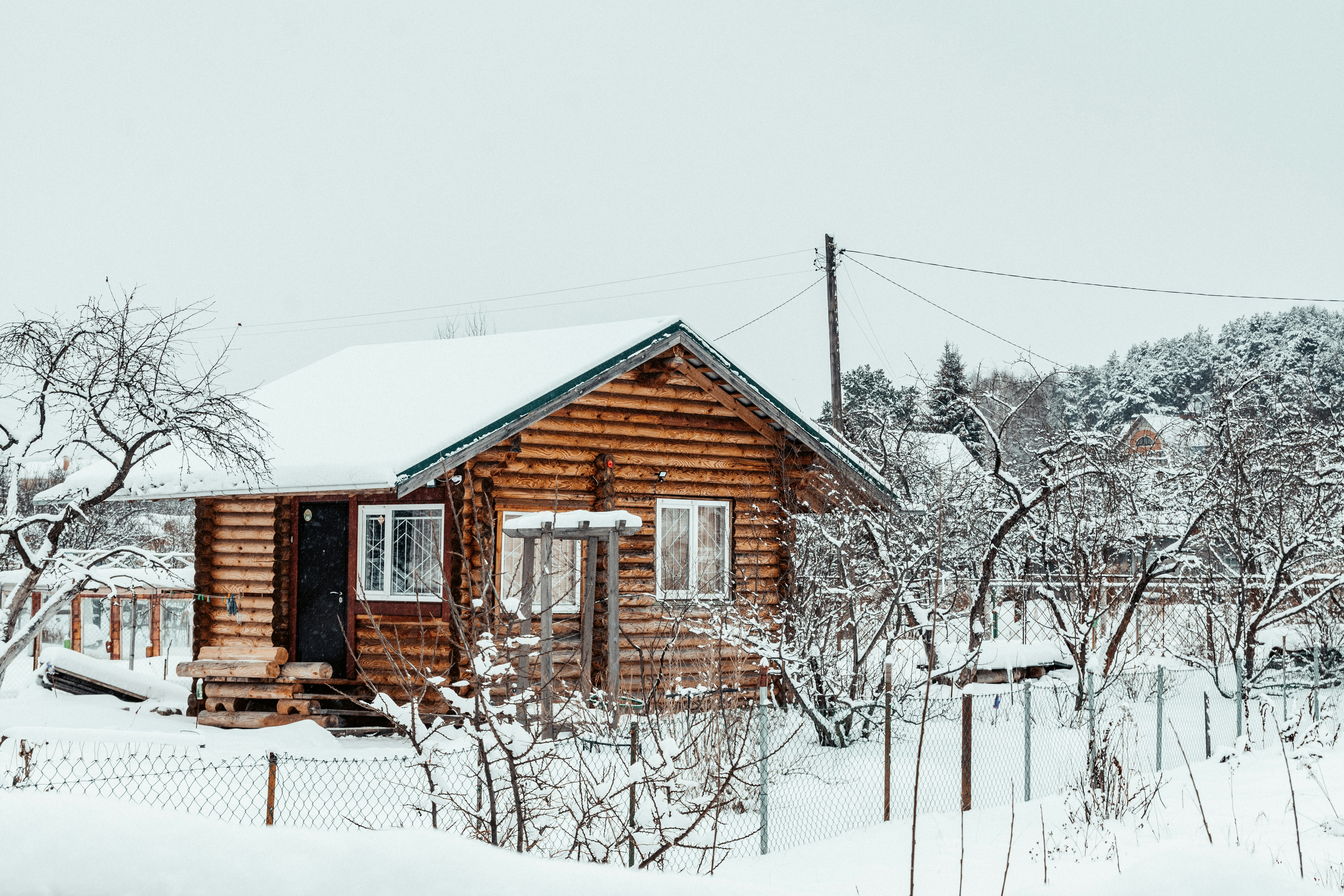 a small log cabin in the middle of a snowy field