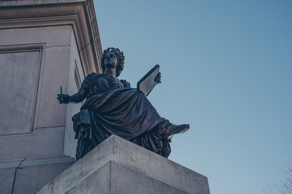 a statue of a woman reading a book