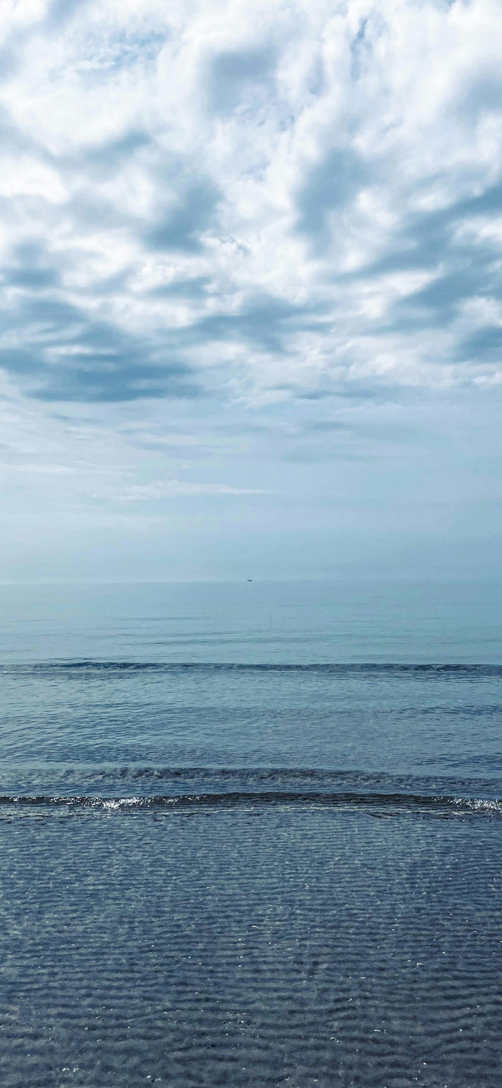 a person walking on the beach carrying a surfboard