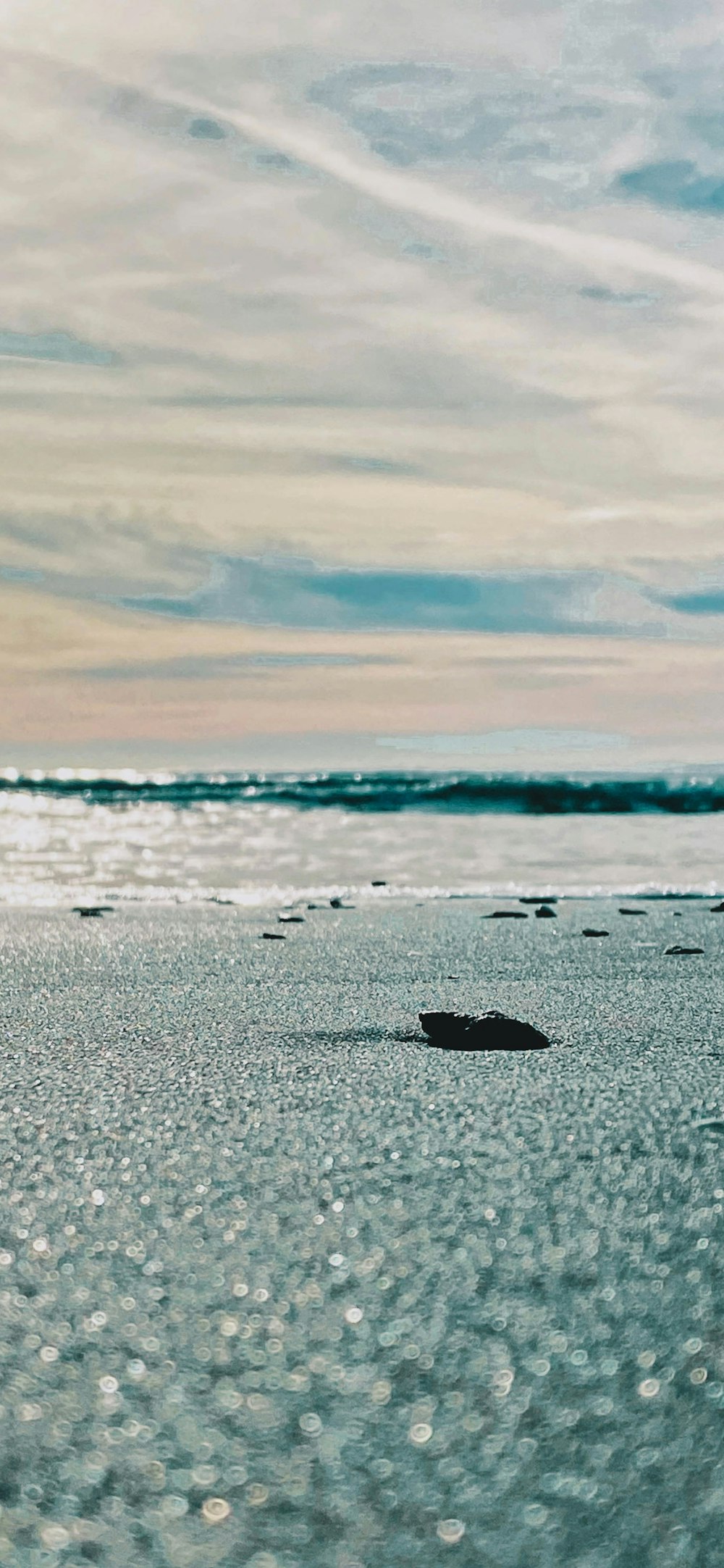 a person walking on a beach with a surfboard