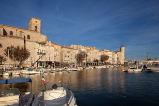a harbor filled with lots of boats next to tall buildings