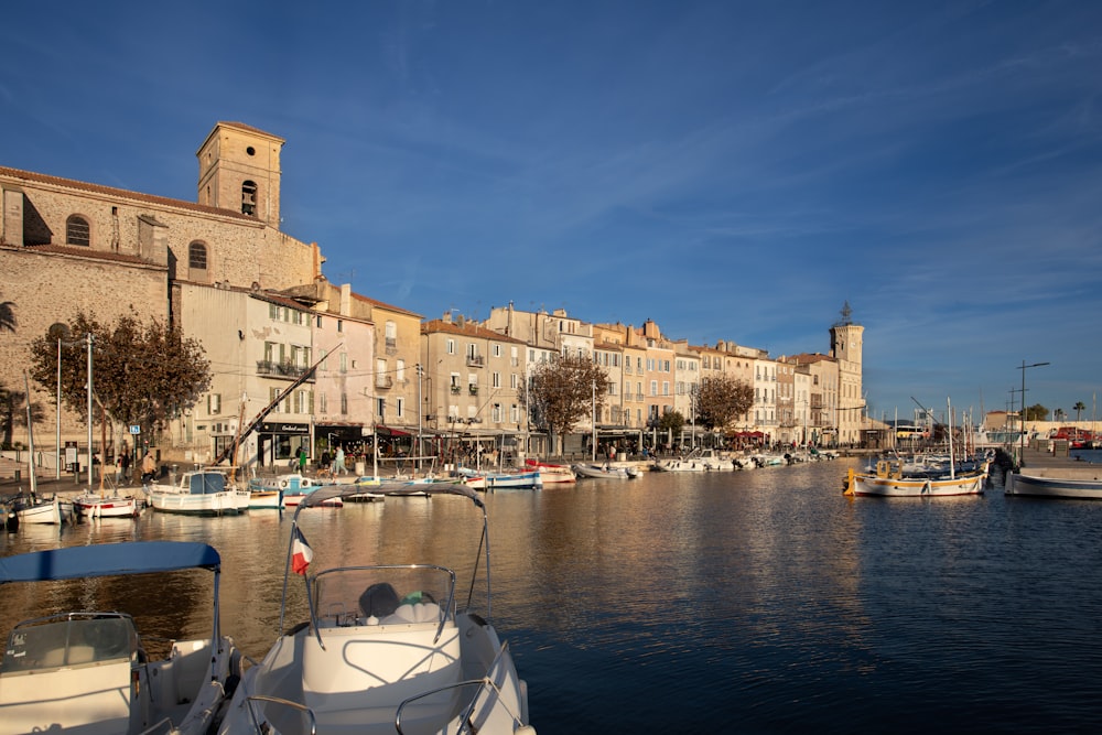 a harbor filled with lots of boats next to tall buildings