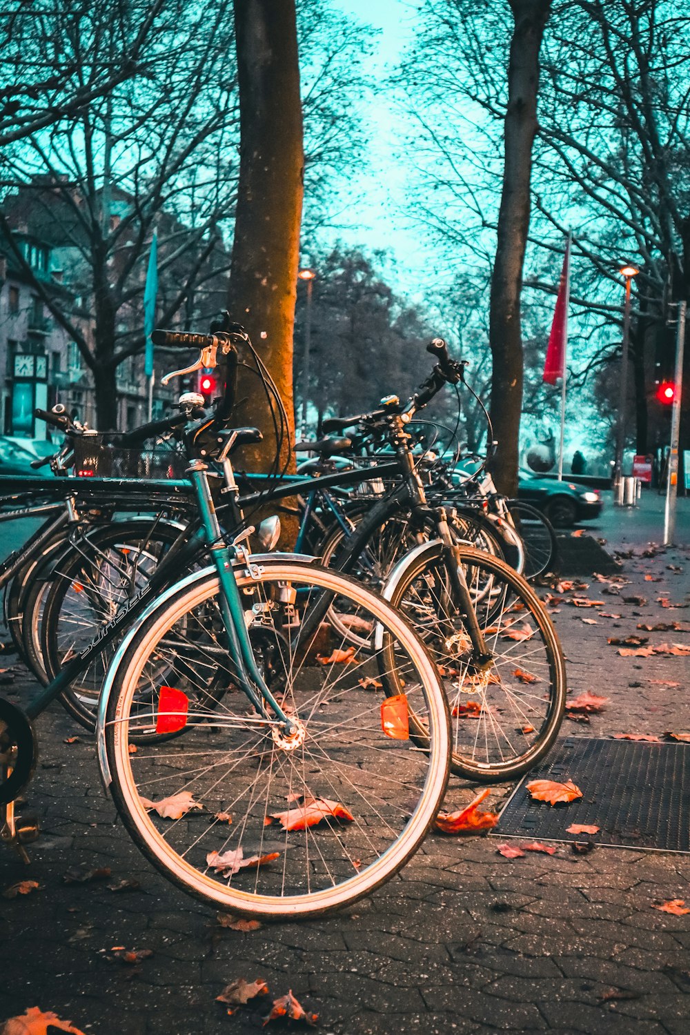 a row of parked bikes sitting next to each other on a sidewalk