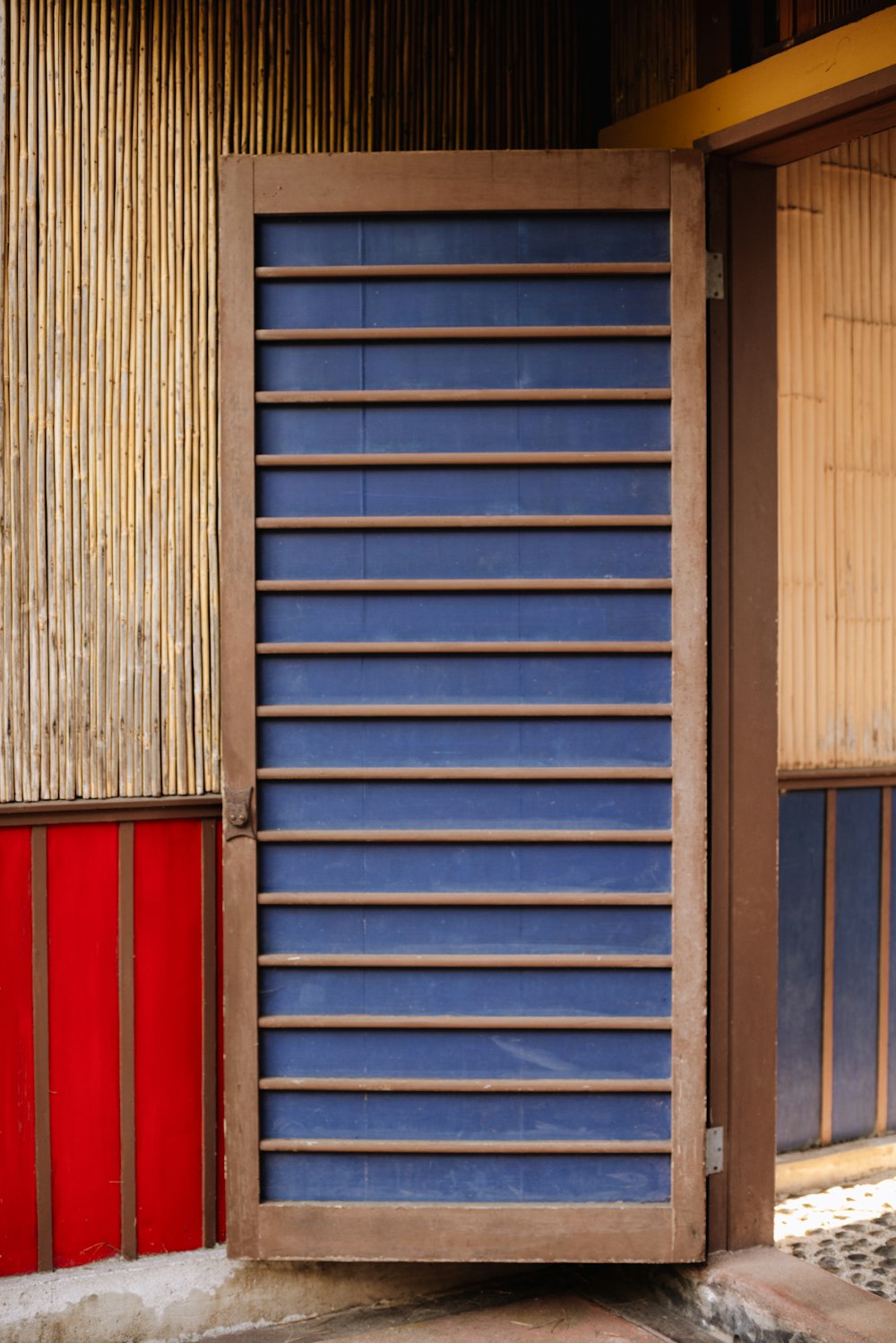 a blue and red door sitting next to a building