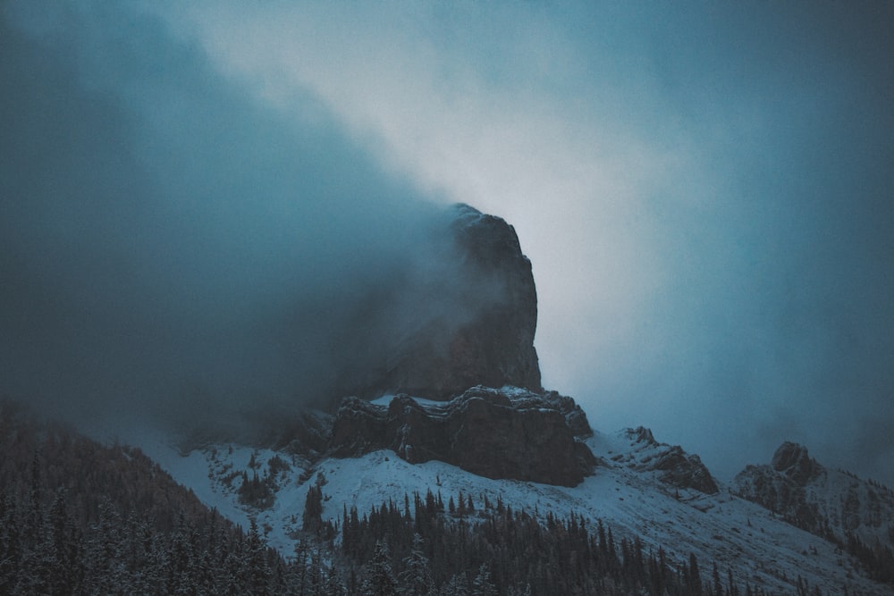 a mountain covered in snow and fog