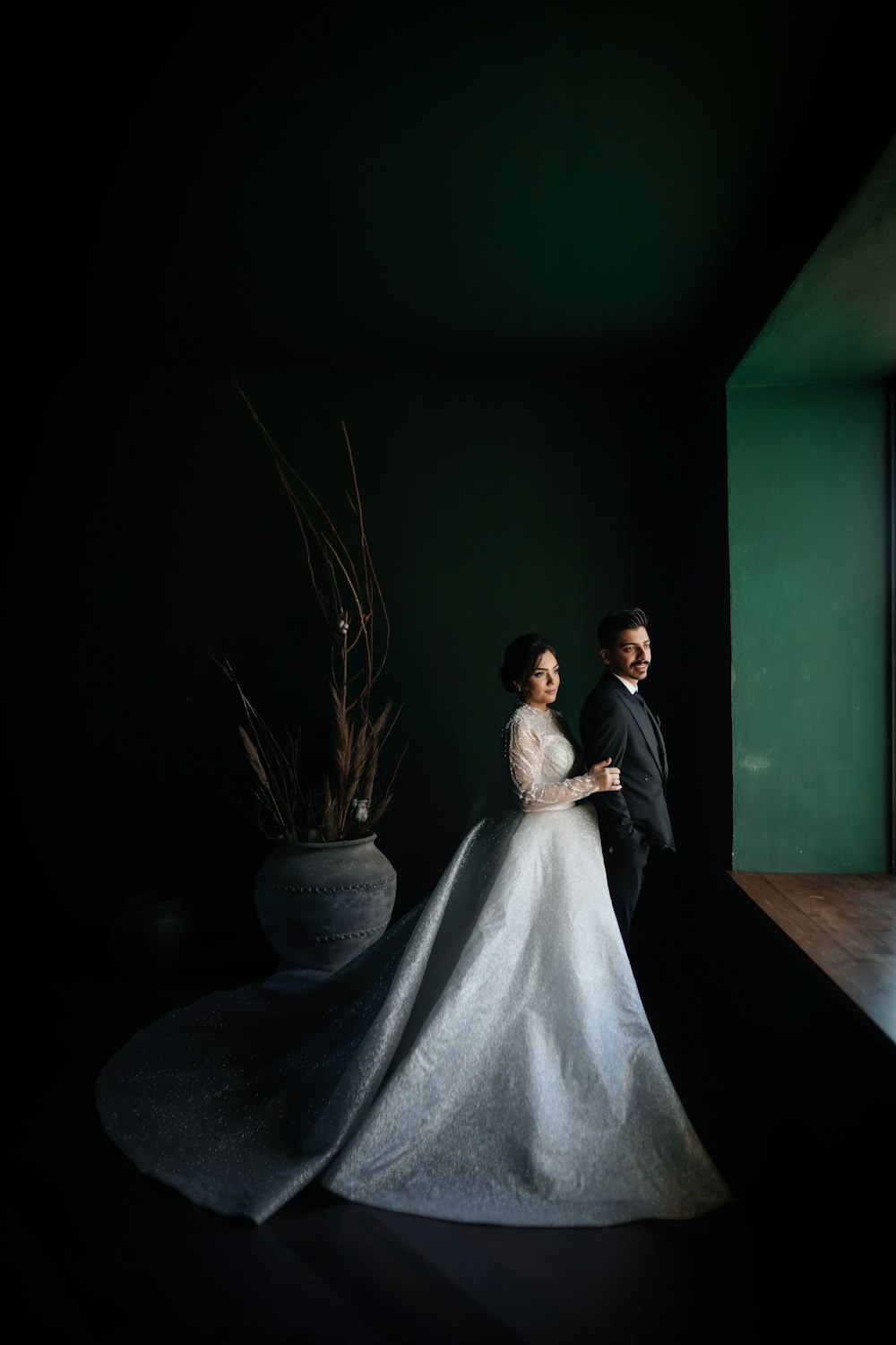 a bride and groom standing in a dark room