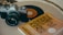 An analog camera, a vinyl record, and a book titled 'The Subtle Art of Not Giving a F*ck' are placed on a flat surface, suggesting a blend of photography, music, and literature.