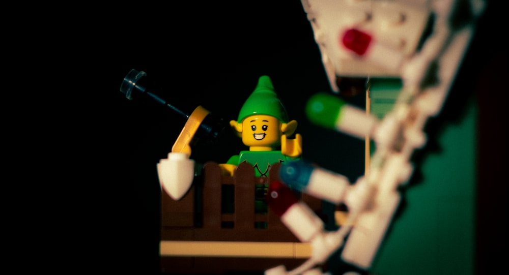 Un elfo de Lego con un sombrero verde y un cepillo de dientes