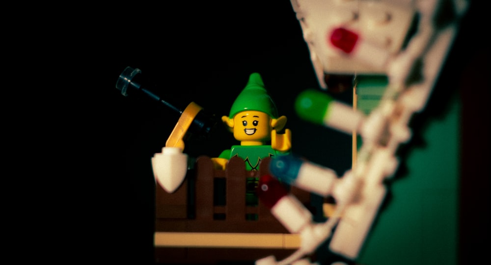 a lego elf with a green hat and a toothbrush