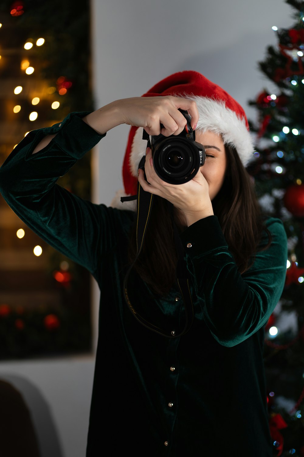 a woman taking a picture of a christmas tree