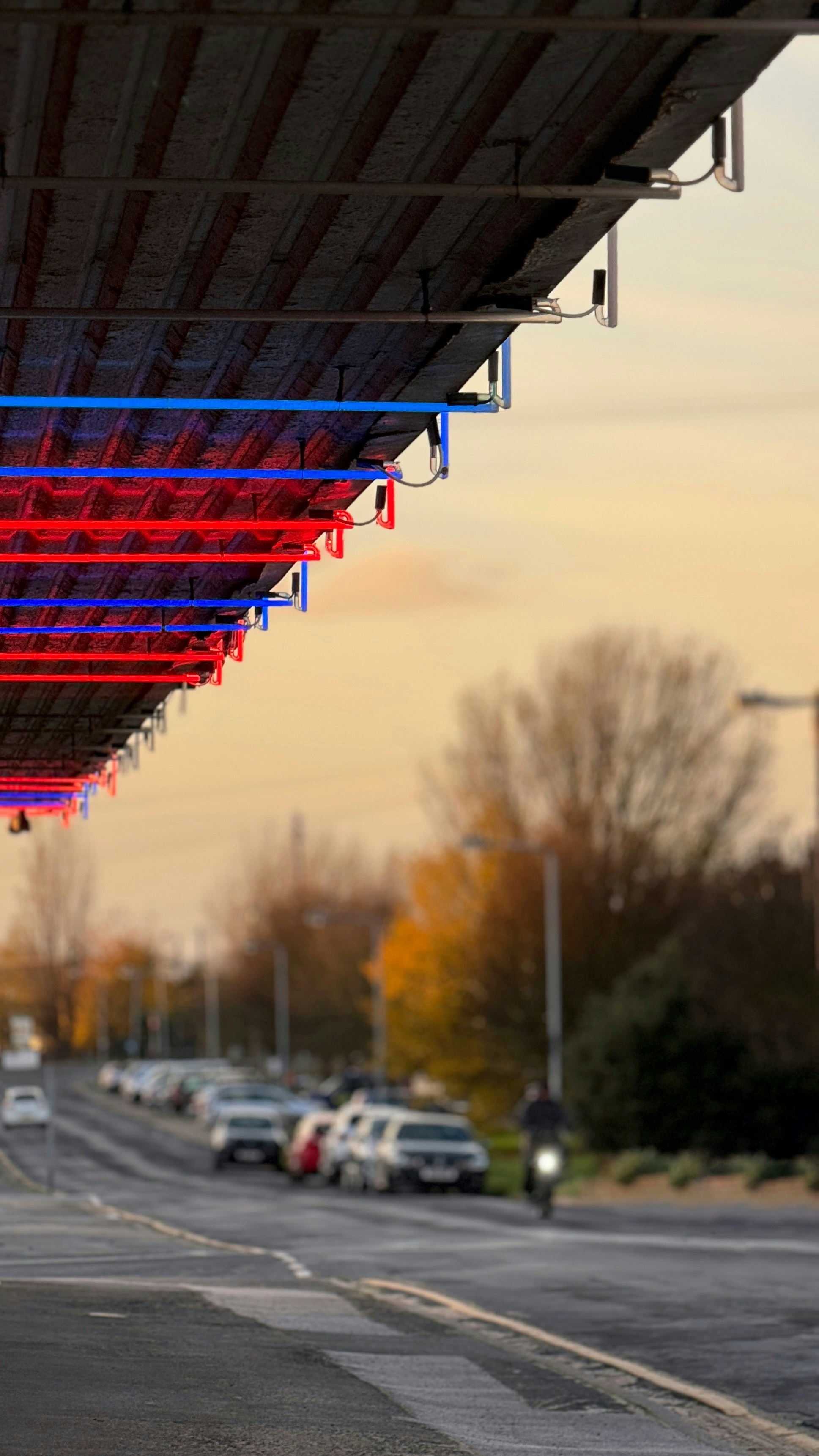 una fila di auto parcheggiate sotto un parcheggio coperto