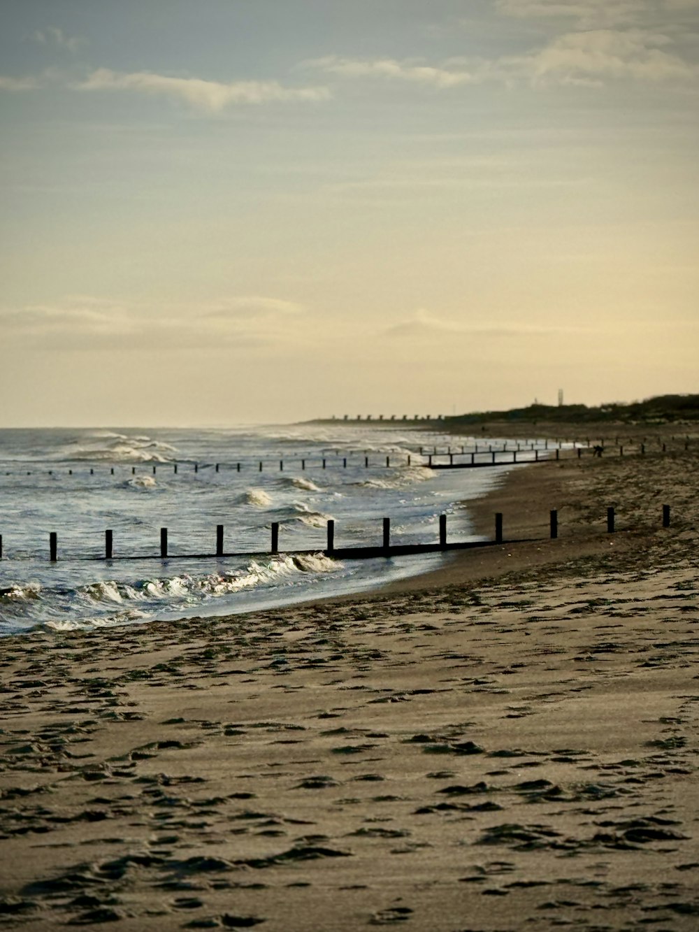 a sandy beach with waves coming in to shore