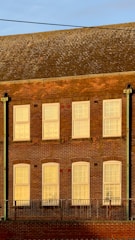 Exterior view of a building showing durable metal and brick window sills in natural light.
