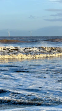 Solar panels installed on a coastal island with waves gently lapping nearby, illustrating sustainable energy in harmony with nature.