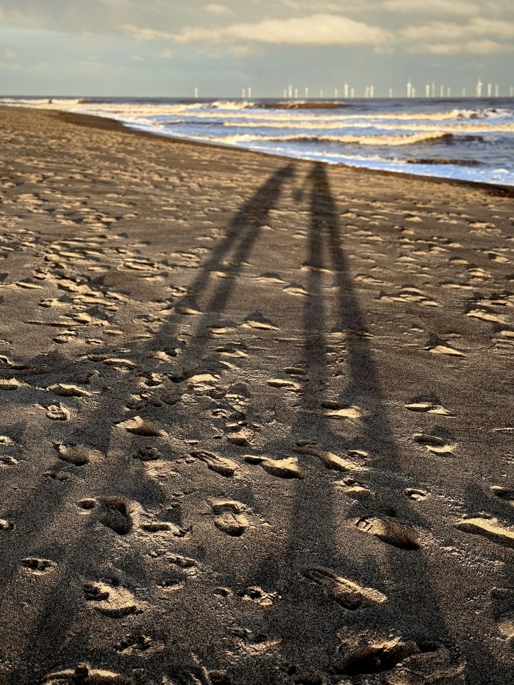a shadow of a person standing on a beach