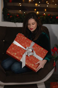 A joyful woman unboxing a festive combo package surrounded by traditional decor.