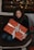 Smiling young woman happily unwrapping a gift box indoors.