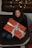 Smiling young woman happily unwrapping a gift box indoors.