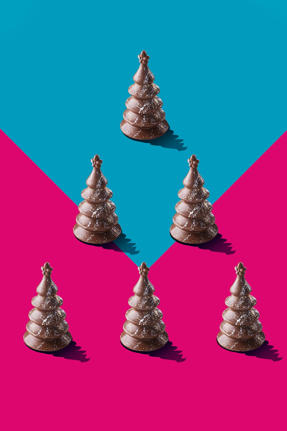 a group of small christmas trees sitting on top of a pink and blue background