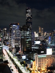 A vibrant cityscape with illuminated billboards at night.