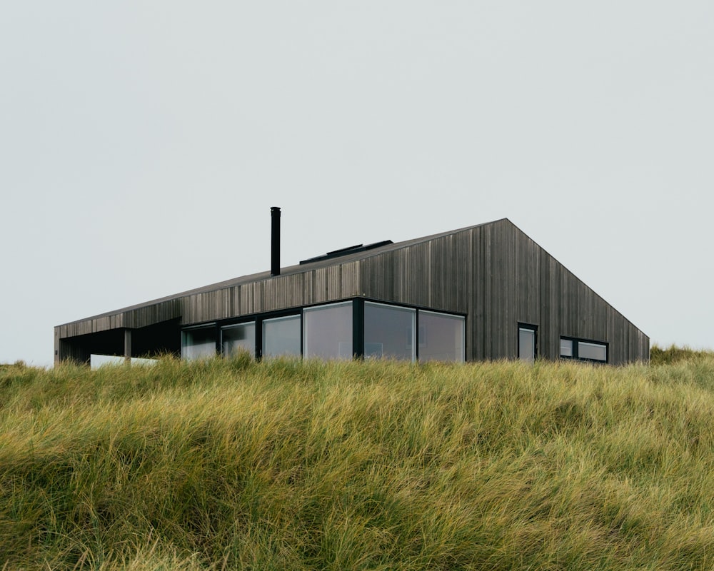 una casa en la cima de una colina cubierta de hierba