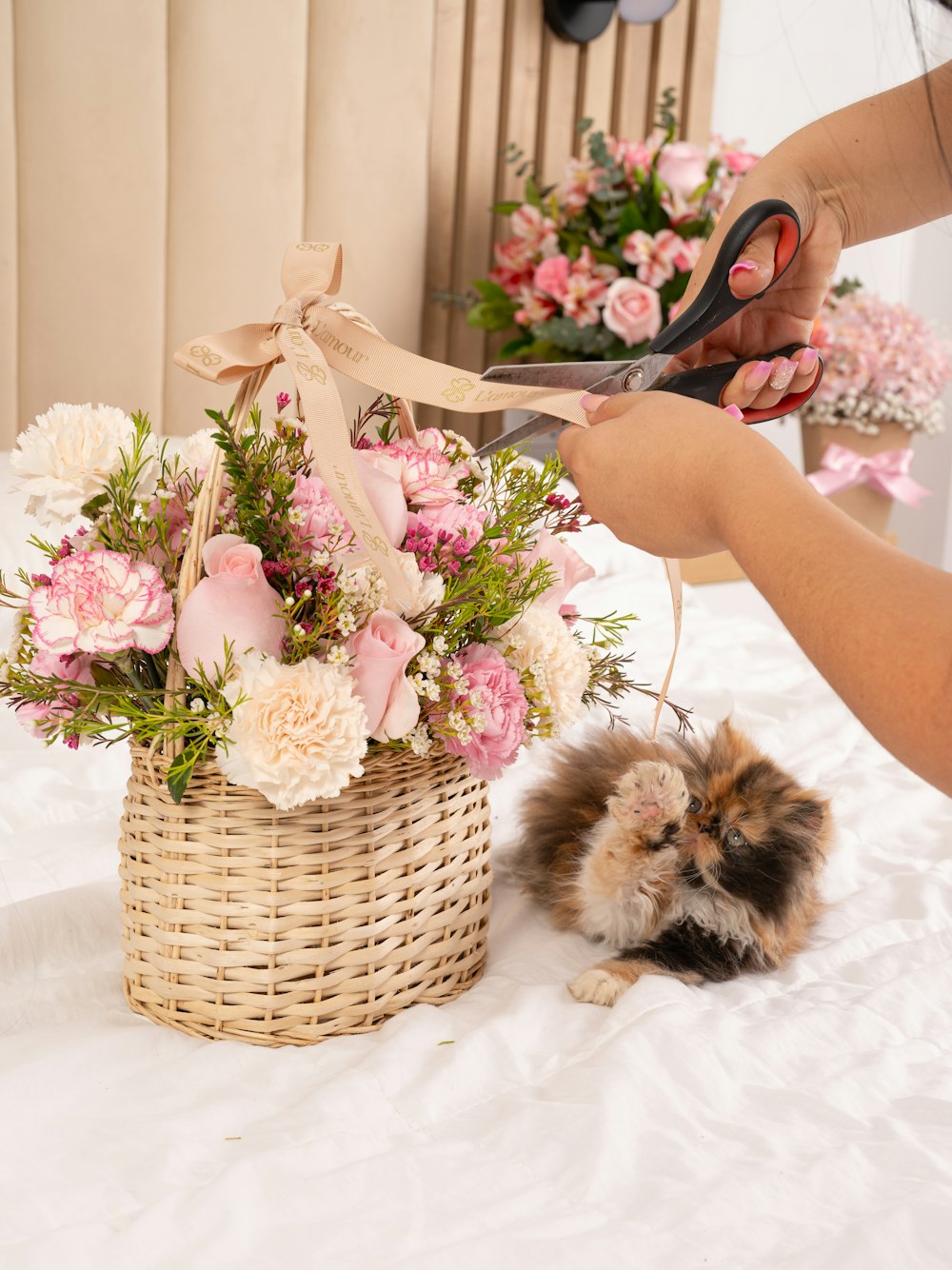 a person cutting a flower arrangement in a basket