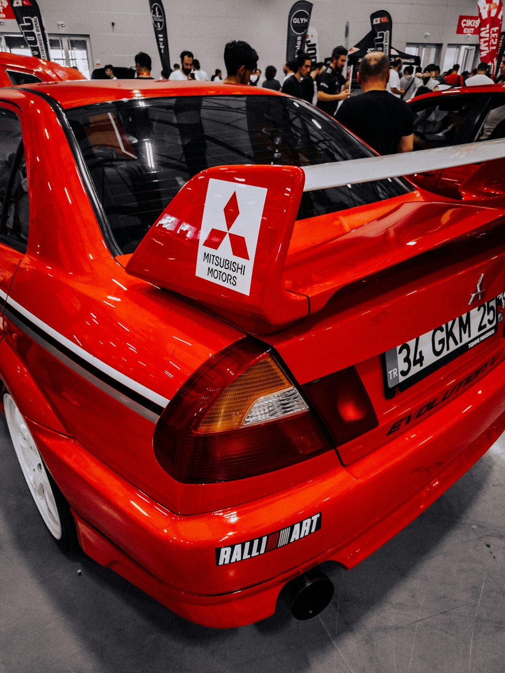 a red car is parked in a showroom