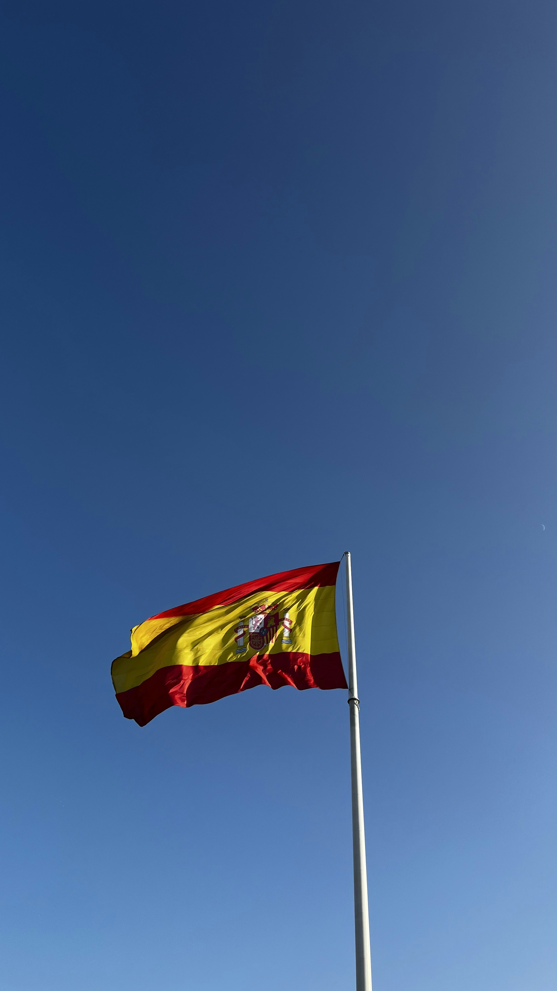 a flag flying in the wind on a sunny day